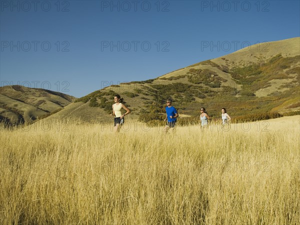 Group of people running in field, Utah, United States. Date : 2007