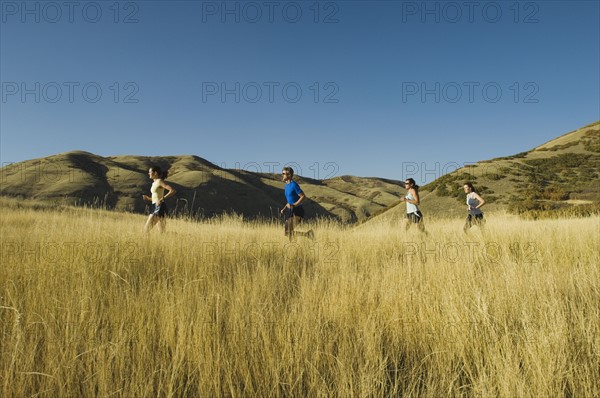 Group of people running in field, Utah, United States. Date : 2007