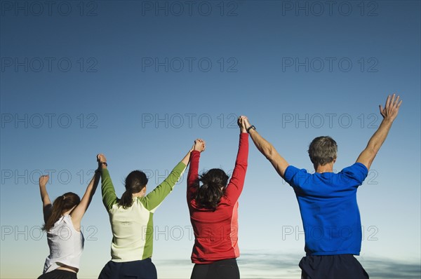 Rear view of people with arms raised, Salt Flats, Utah, United States. Date : 2007