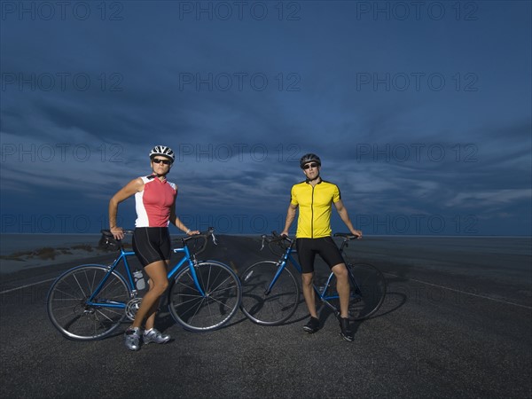 Couple with bicycles on road, Utah, United States. Date : 2007