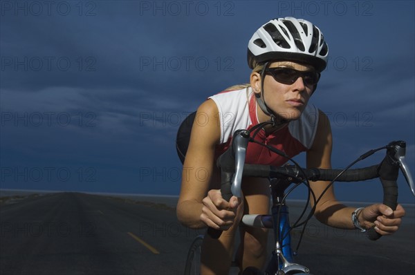 Woman cycling at night, Utah, United States. Date : 2007