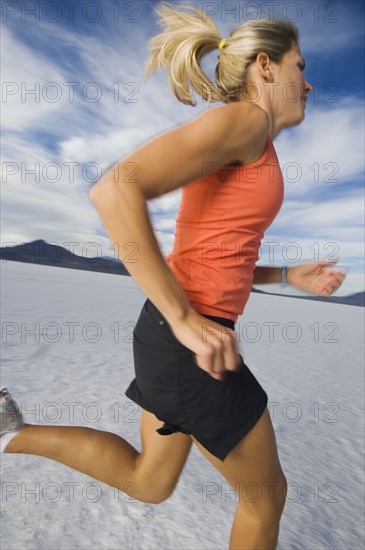 Woman running on salt flats, Utah, United States. Date : 2007