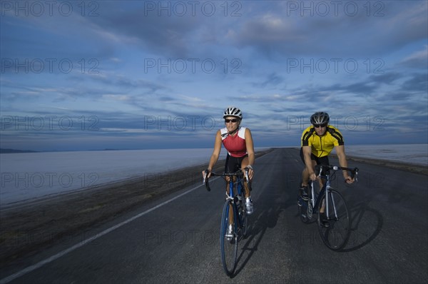 Couple cycling on road, Utah, United States. Date : 2007