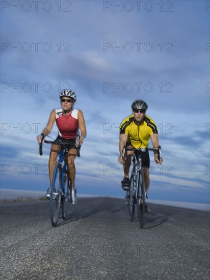 Couple cycling on road, Utah, United States. Date : 2007