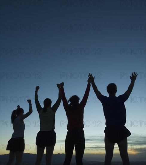 Silhouette of people with arms raised, Salt Flats, Utah, United States. Date : 2007