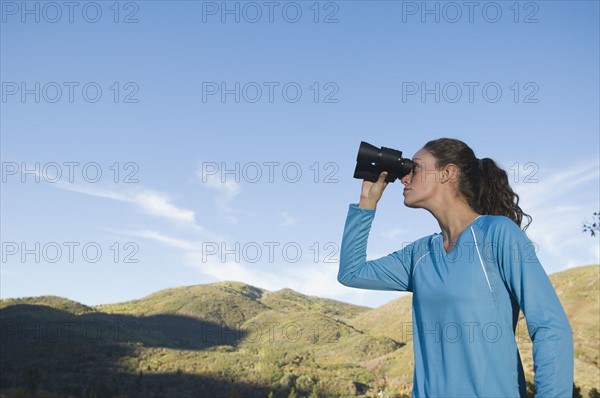 Woman looking through binoculars, Utah, United States. Date : 2007