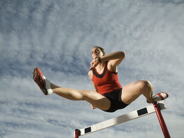 Female athlete jumping hurdle, Utah, United States. Date : 2007