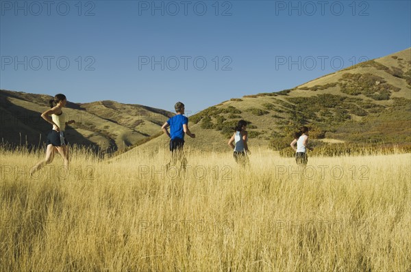 Group of people running in field, Utah, United States. Date : 2007