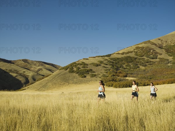 Group of people running in field, Utah, United States. Date : 2007