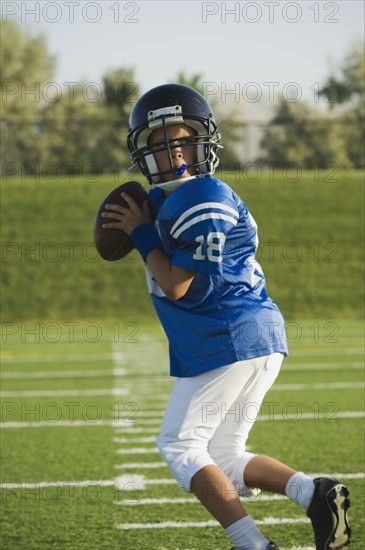 Young football player running with ball. Date : 2007