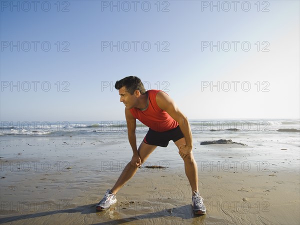 Man stretching at beach. Date : 2007