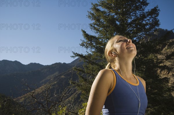 Woman listening to mp3 player, Utah, United States. Date : 2007