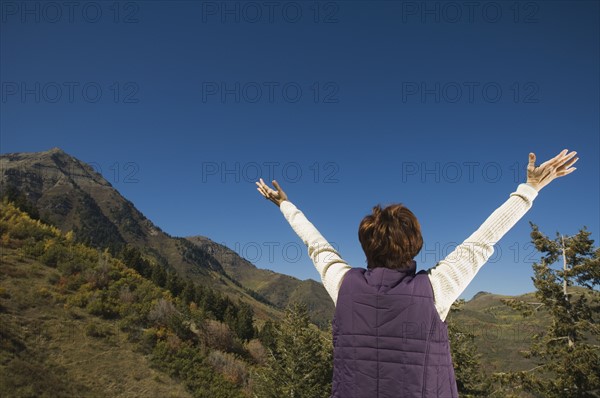 Rear view of woman with arms raised, Utah, United States. Date : 2007