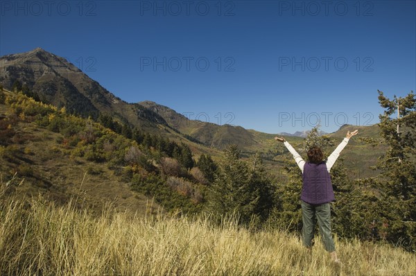 Rear view of woman with arms raised, Utah, United States. Date : 2007