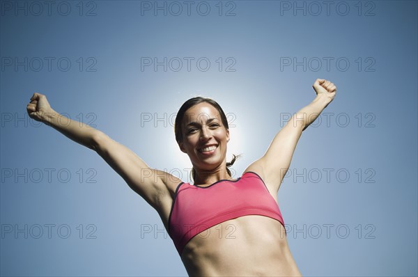 Woman in athletic gear with arms raised. Date : 2007