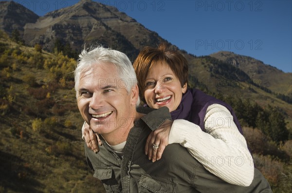 Senior man giving wife piggy back ride, Utah, United States. Date : 2007