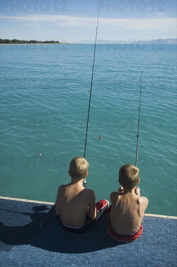 Brothers fishing off dock in lake, Utah, United States. Date : 2007