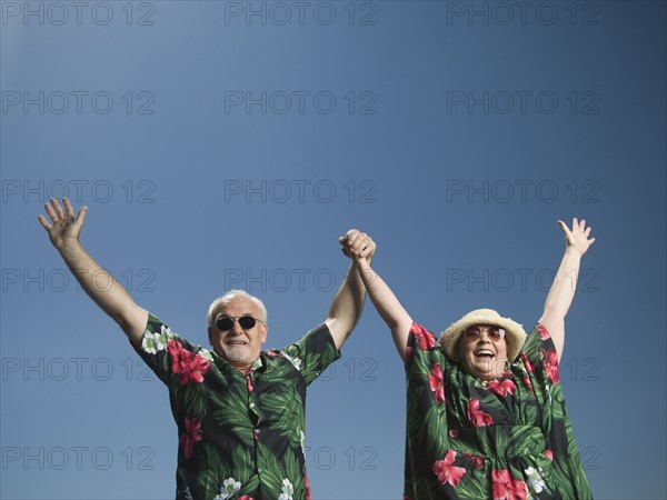Senior couple with arms raised. Date : 2007