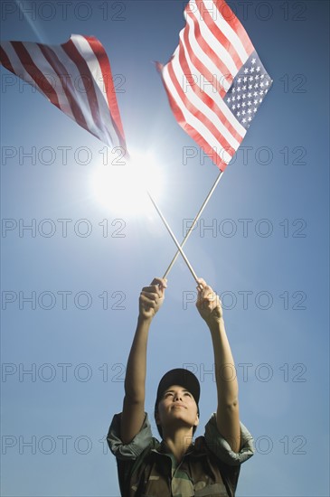 Female army soldier holding American flags. Date : 2007