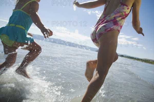 Sisters running in water, Utah, United States. Date : 2007