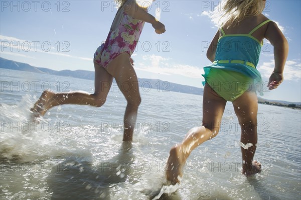 Sisters running in water, Utah, United States. Date : 2007