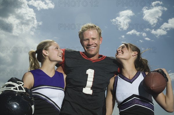 Football player hugging cheerleaders. Date : 2007