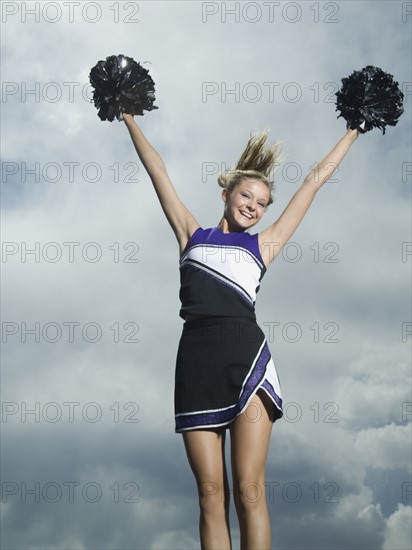 Cheerleader with pom poms jumping. Date : 2007