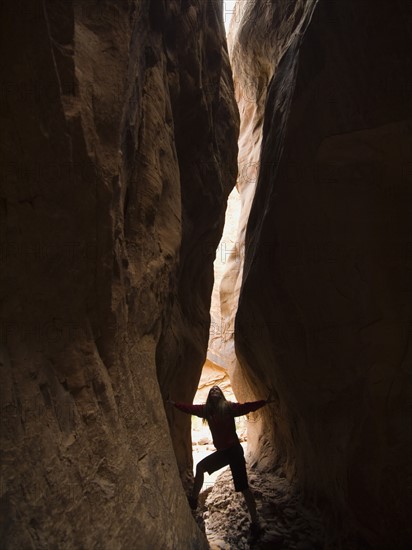 Woman looking up between rock formations. Date : 2007