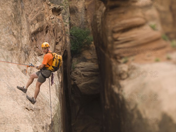 Man in rappelling gear at top of cliff. Date : 2007