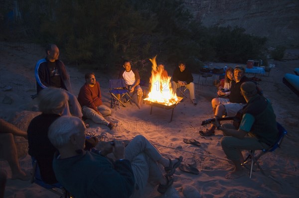 People relaxing around camp fire. Date : 2007