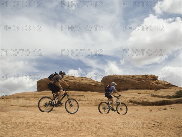 Couple riding mountain bikes in desert. Date : 2007