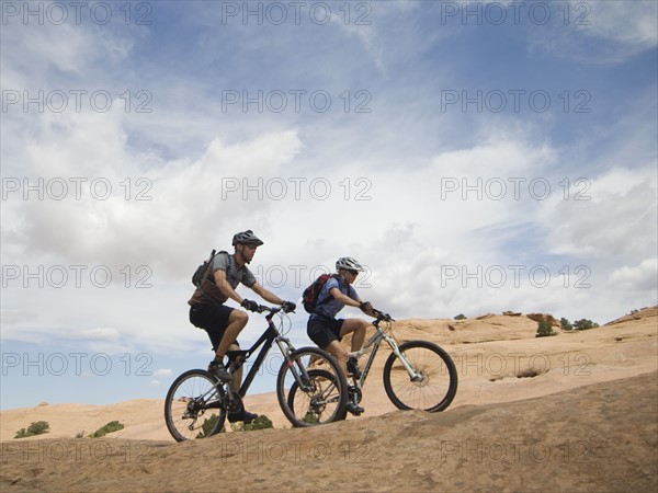 Couple riding mountain bikes in desert. Date : 2007