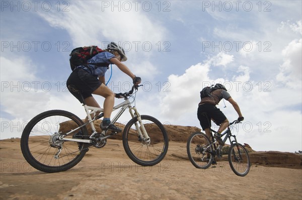 Couple riding mountain bikes in desert. Date : 2007