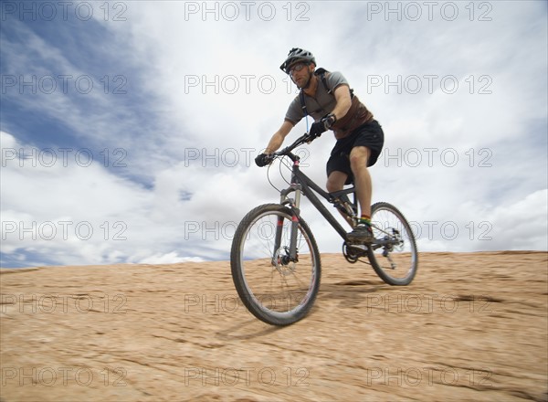 Man riding mountain bike on rock formation. Date : 2007