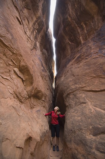 Woman looking up between rock formations. Date : 2007