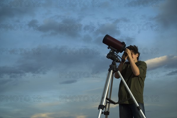 Man using telescope on tripod. Date : 2007