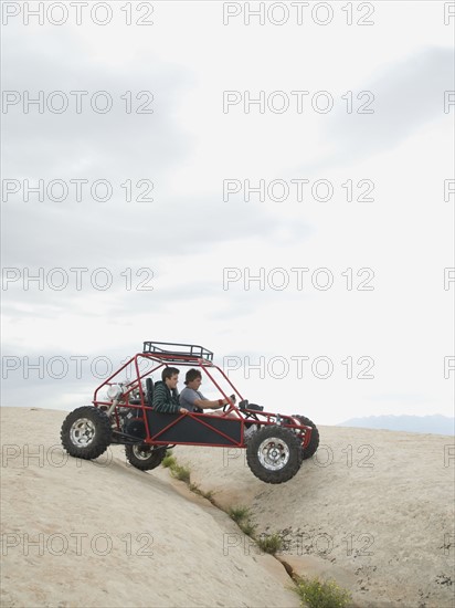 People in off-road vehicle on rock formation. Date : 2007