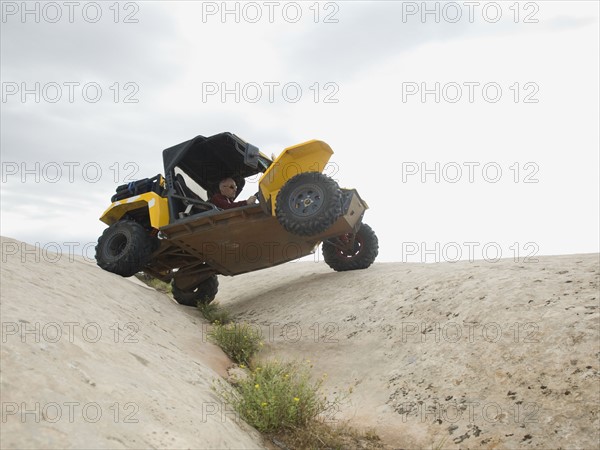 People in off-road vehicle on rock formation. Date : 2007