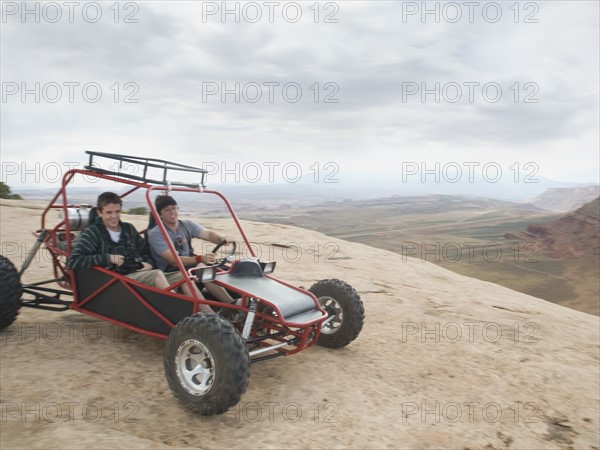 People in off-road vehicle on rock formation. Date : 2007