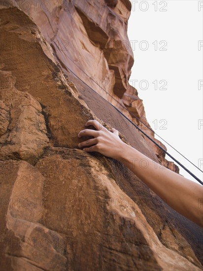 Close up of woman’s arm rock climbing. Date : 2007
