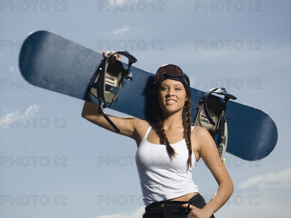 Snowboarder holding board on shoulder. Date : 2007