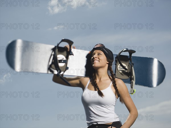 Snowboarder holding board on shoulder. Date : 2007