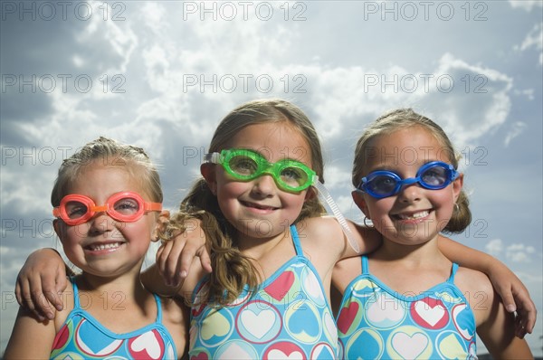 Three young sisters wearing swimming goggles. Date : 2007