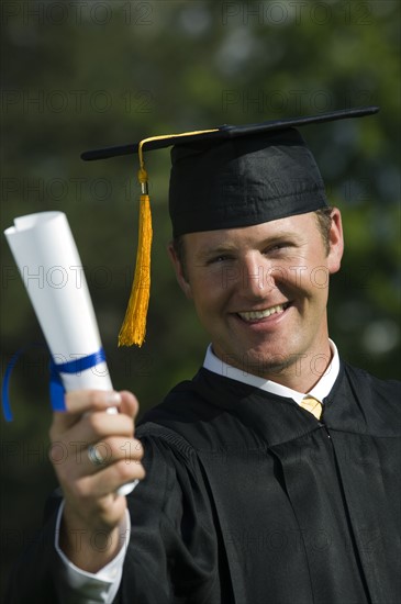 Male graduate holding diploma. Date : 2007