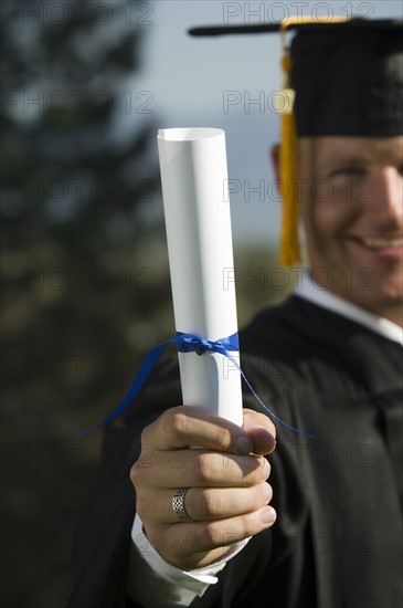 Male graduate holding diploma. Date : 2007