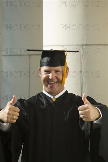 Male graduate giving thumbs up. Date : 2007