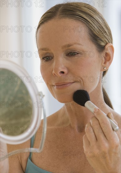Woman applying makeup.