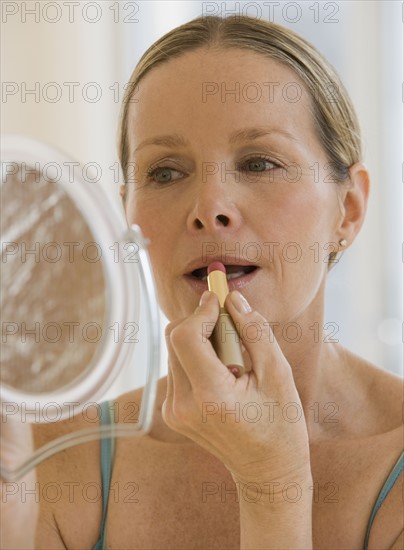 Woman applying lipstick.