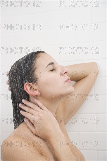 Woman standing under shower.