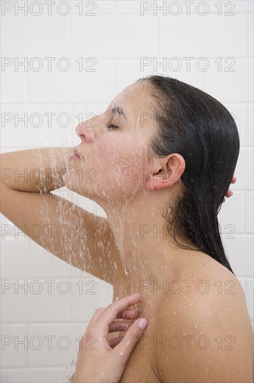 Woman standing under shower.